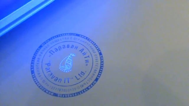Печать с защитой от подделки, которая светится под ультрафиолетовым фонарём.