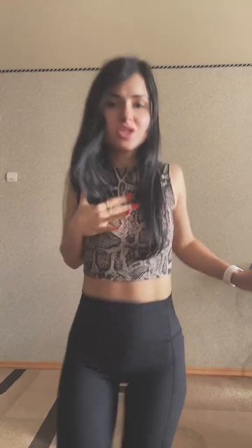 Красивая девушка танцует под музыку в леггинсах