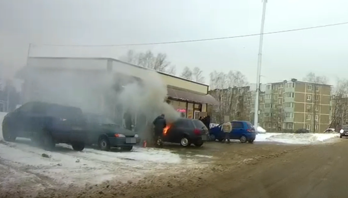 Горит машина около кафе.